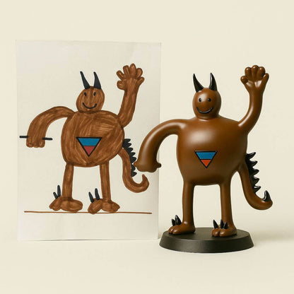 Cheerful brown monster figurine with horns and a blue-red triangle chest emblem, handcrafted by OstanesKids from a child’s original artwork. A fun and memorable custom gift for kids.