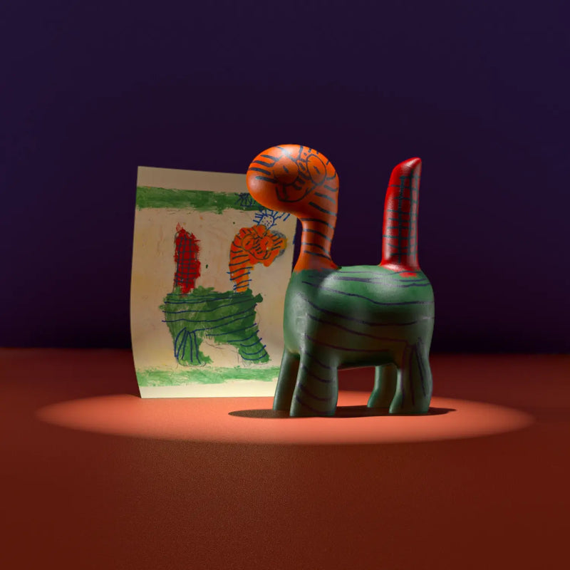 Striped green and red animal figurine recreated from a kid’s colourful drawing, showing a tiger-like fantasy creature.
