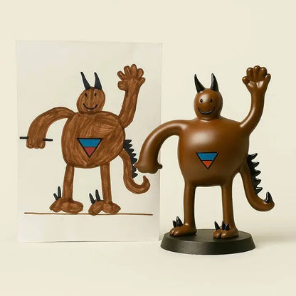OstanesKids custom brown monster figurine from child’s drawing with horns, tail, and waving hand.