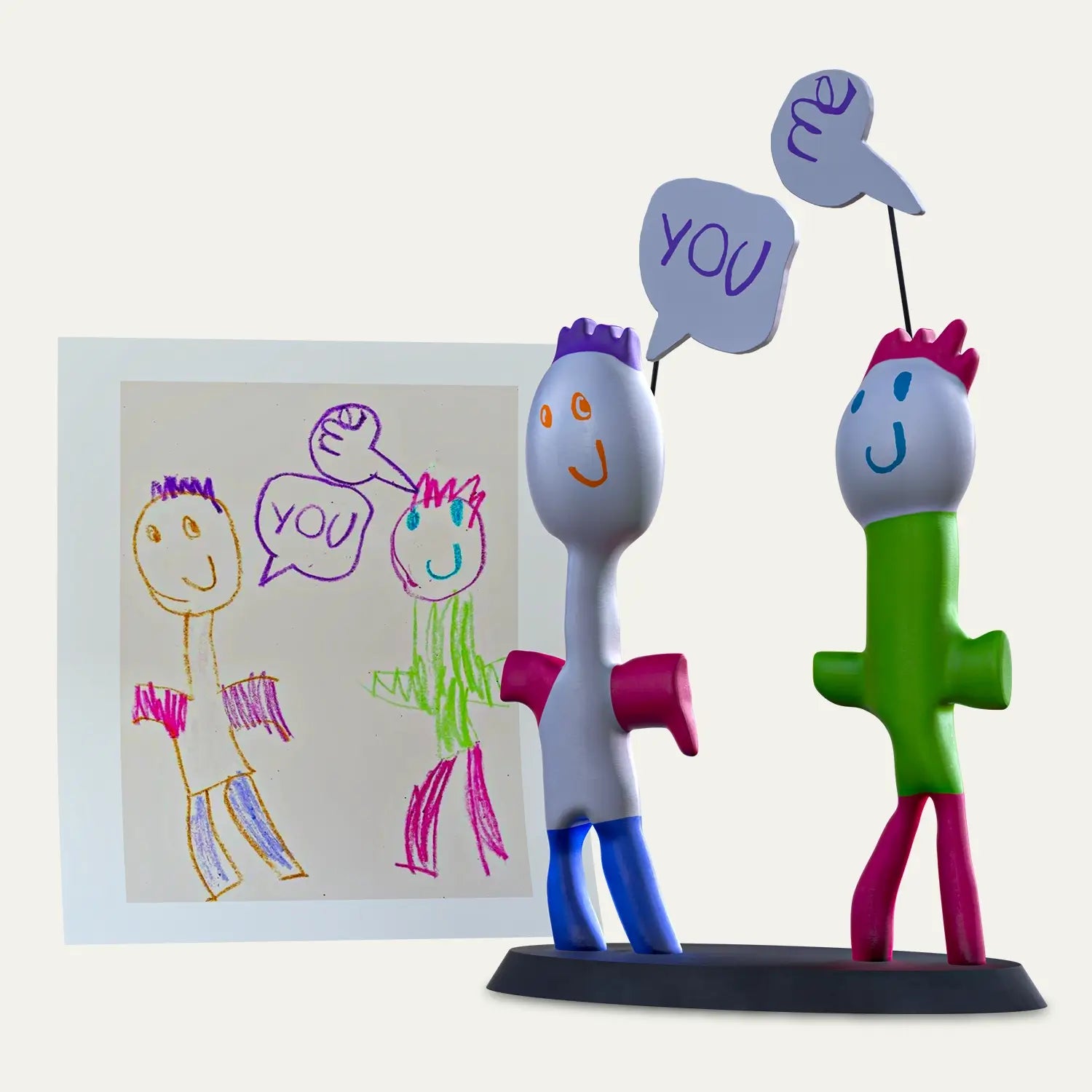 Two smiling characters saying “You” in a crayon speech bubble come to life as a playful figurine pair, made from a child’s drawing and embedded with audio for a meaningful gift.