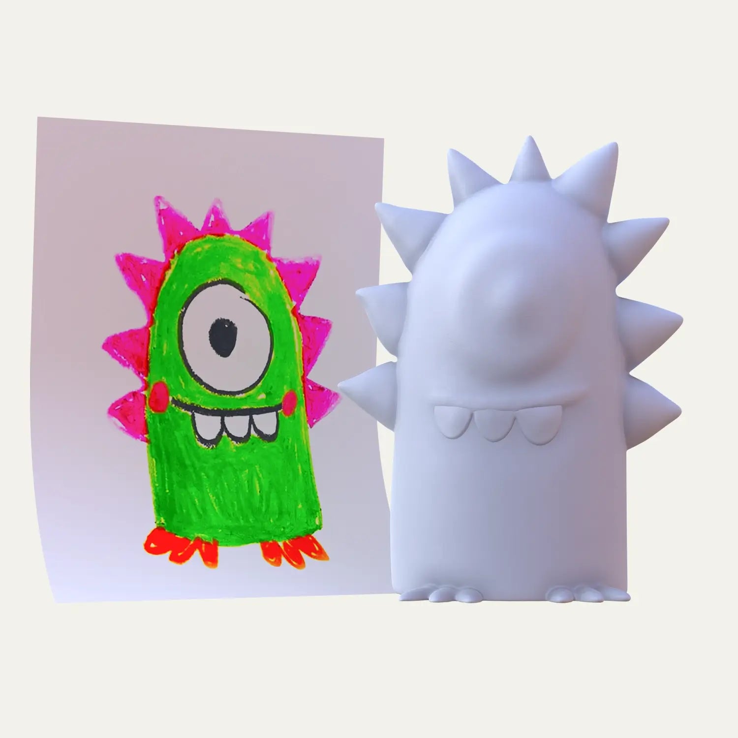A one-eyed green creature from a colourful drawing stands beside its spiked unpainted 3D version, imagined as a unique voice-enabled keepsake gift.